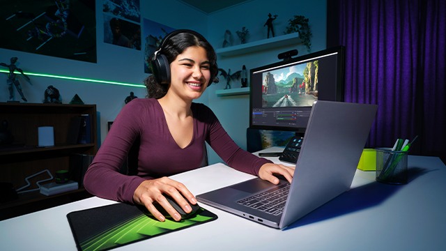 Studentka w słuchawkach gra na laptopie GeForce RTX przy biurku