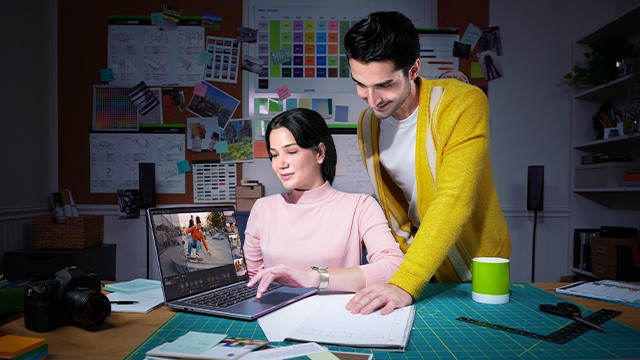 Dwoje studentów pracuje nad projektem kreatywnym na laptopie