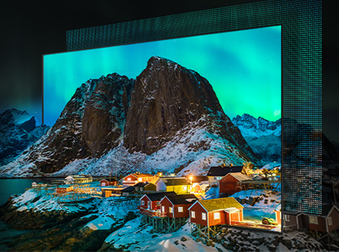 Telewizor Samsung OLED w ciemnym wnętrzu, na ekranie nocny krajobraz z zieloną zorzą polarną nad górami i rozświetloną nadmorską miejscowością. Widoczna głęboka czerń nieba i nasycone kolory.
